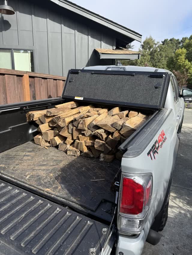 The pickup bed stacked full of split firewood