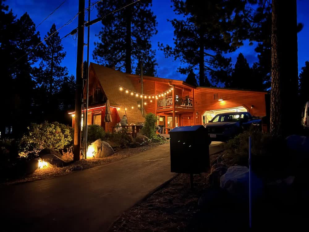 The cabin at night with string lights glowing